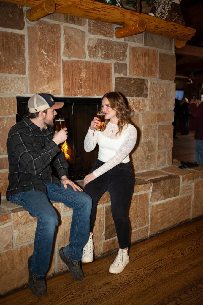 Couple enjoying drinks at their brewery engagement session at Leinenkugel's Leinie Lodge in Chippewa Falls, WI. true color photo by Maddie, an Eau Claire wedding photographer