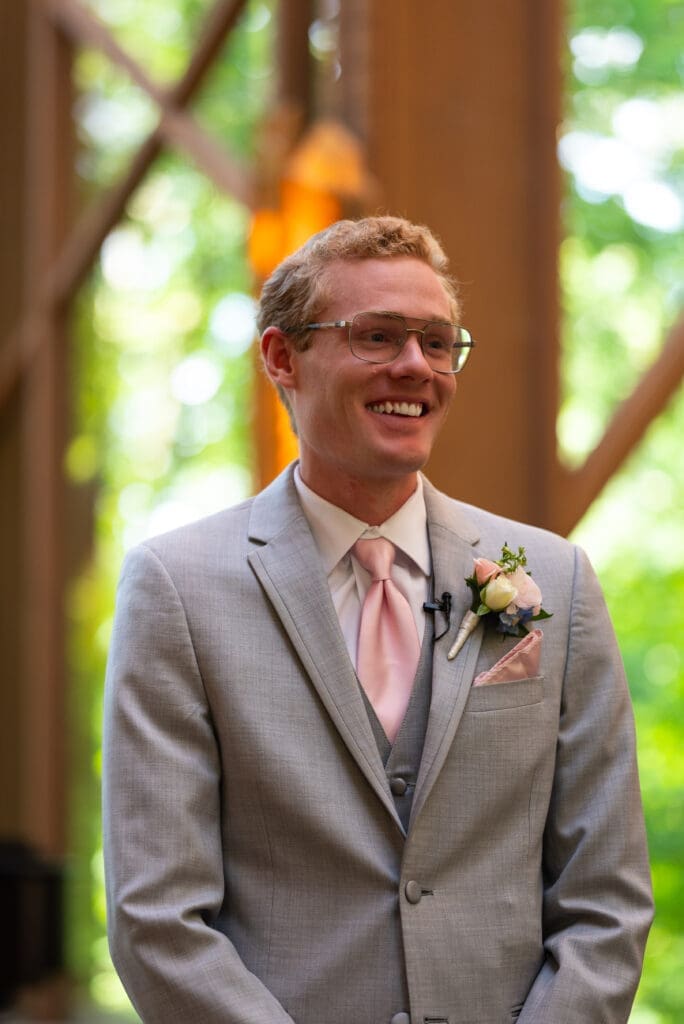 Groom smiling at bride coming down the aisle. True color wedding photographer