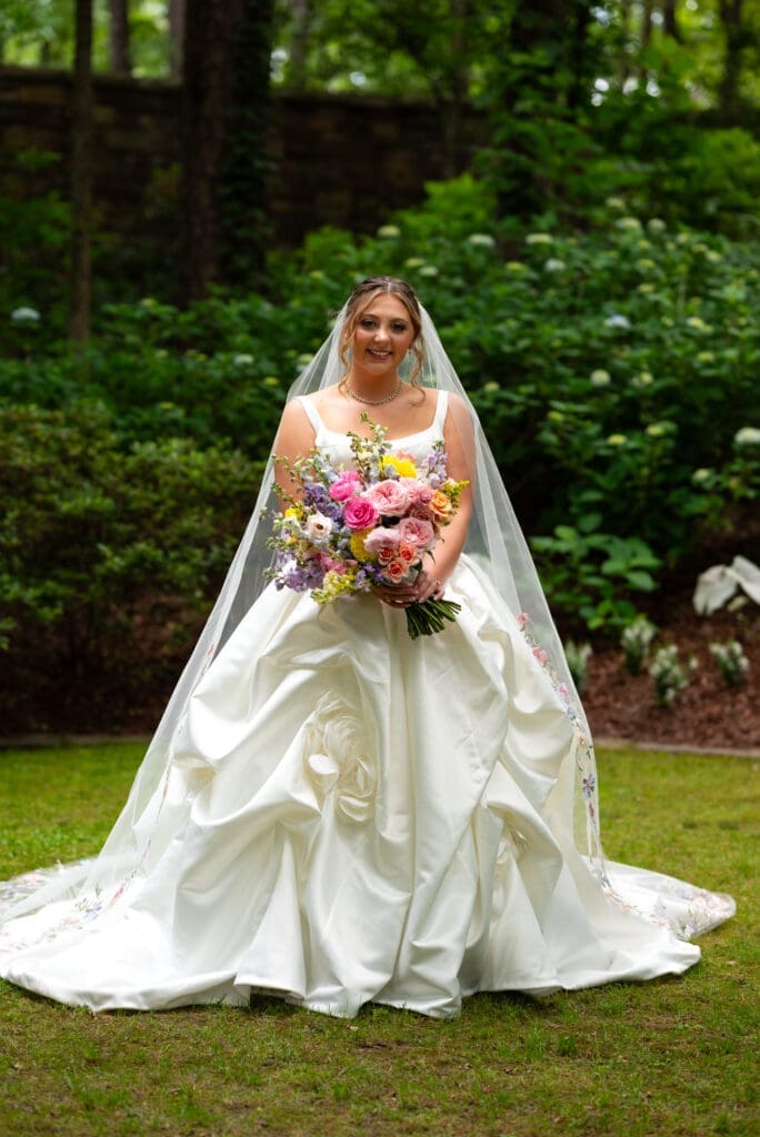 Bride holding colorful spring bouquet at Anthony Chapel, Hot Springs, AR. Photographed by Maddie, a true to color editorial wedding photographer based out of Wisconsin.