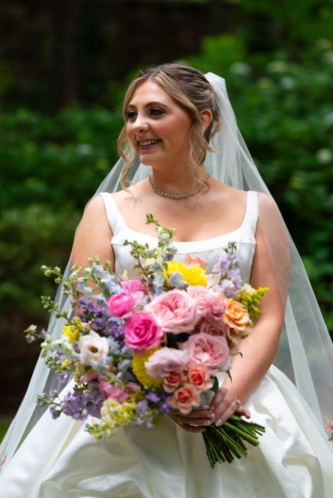 Bridal portrait holding colorful; bouquet at Anthony Chapel in Hot Springs, AR. Photographed by Maddie from Spirited Sage Photography, a true to color wedding photographer.