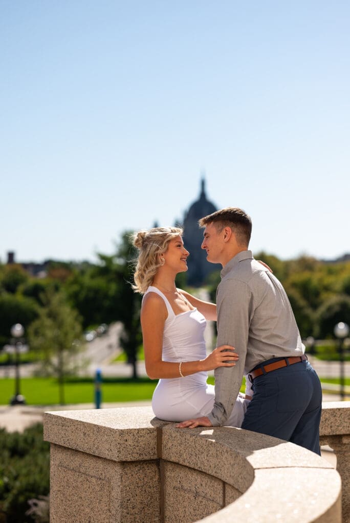 couple in embrace outside the MN State Capitol for their twin cities engagement session, by Maddie a true color traditional wedding photographer