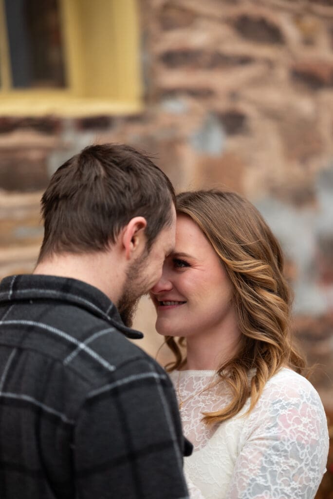 Couple with foreheads together for their brewery engagement session near Eau Claire, WI at The Leinie Lodge in Chippewa Falls, WI