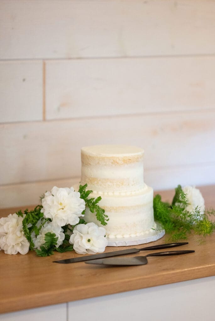 "naked" wedding cake with white florals