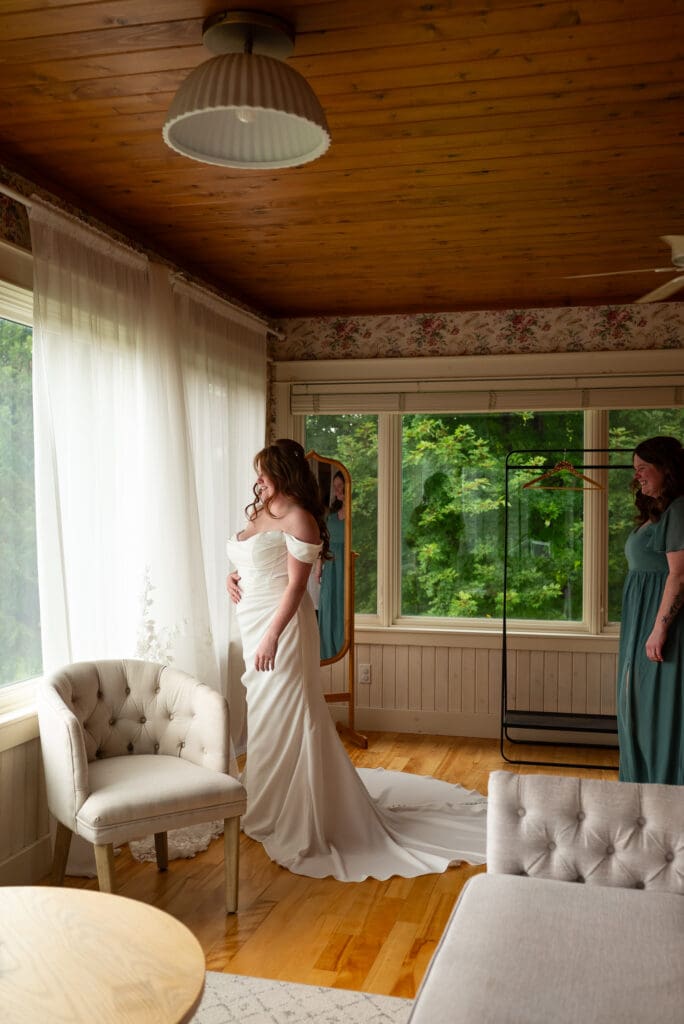 bride looking out windows of La Crosse Wisconsin wedding venue Maidenwood weddings and events in Stockholm, WI. Photographed by Maddie, a documentary wedding photographer from spirited sage photography.