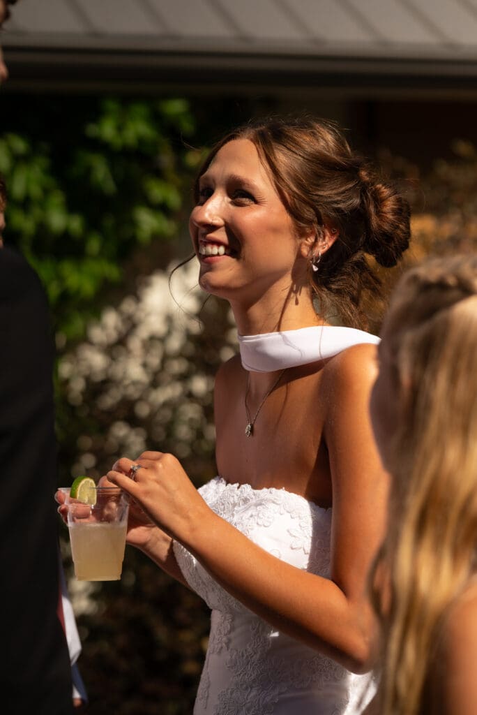 Beautiful bride enjoying a drink and socializing at pepin wedding venue Hidden Meadow and Barn