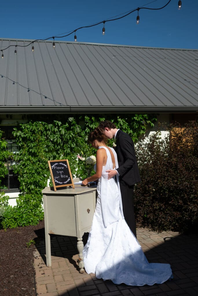 bride and groom read wedding guestbook at hidden meadow and barn, a pepin wedding venue