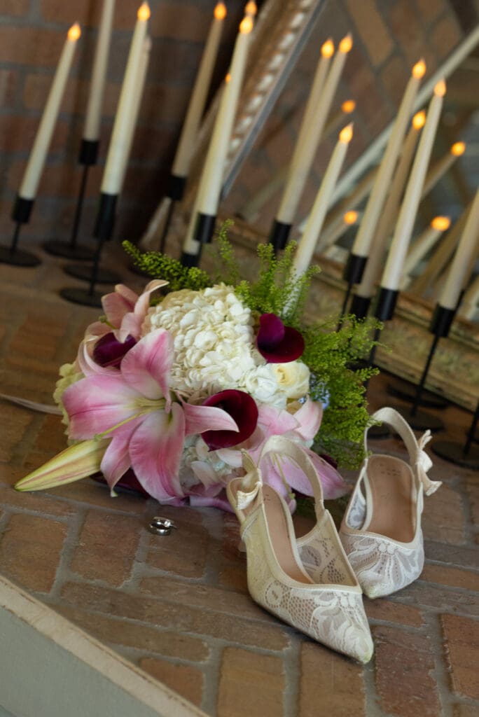 flowers, shoes, and rings on fireplace at Hidden Meadow and Barn in Pepin. Pepin wedding photographers with 2026 availability