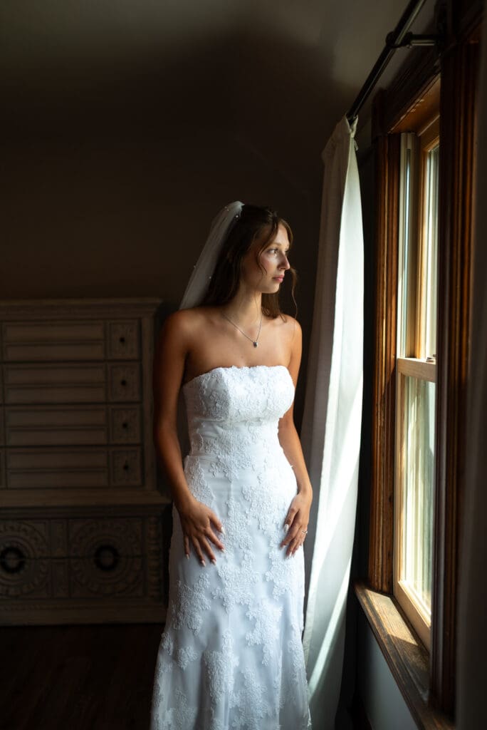 Bridal portrait near window at hidden meadow and barn wedding venue in Pepin, wisconsin. photographed by Maddie, a true to color wedding photographer in wisconsin