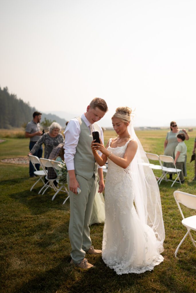 Bride and groom face timing their friend who is watching their dogs and cats back home after the micro wedding ceremony