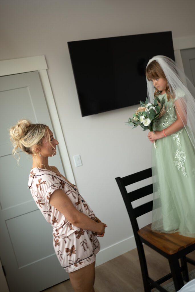 Bride playing dress up with flower girl before micro wedding ceremony at Montana AirBnB