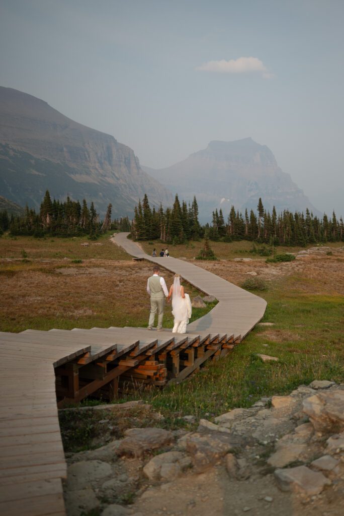 Bride and groom walking at Logan Pass in Montana