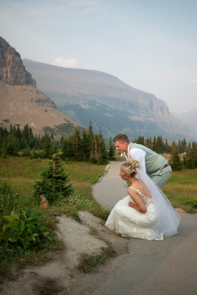 Bride and groom looking at cute little ground squirrel at glacier national park