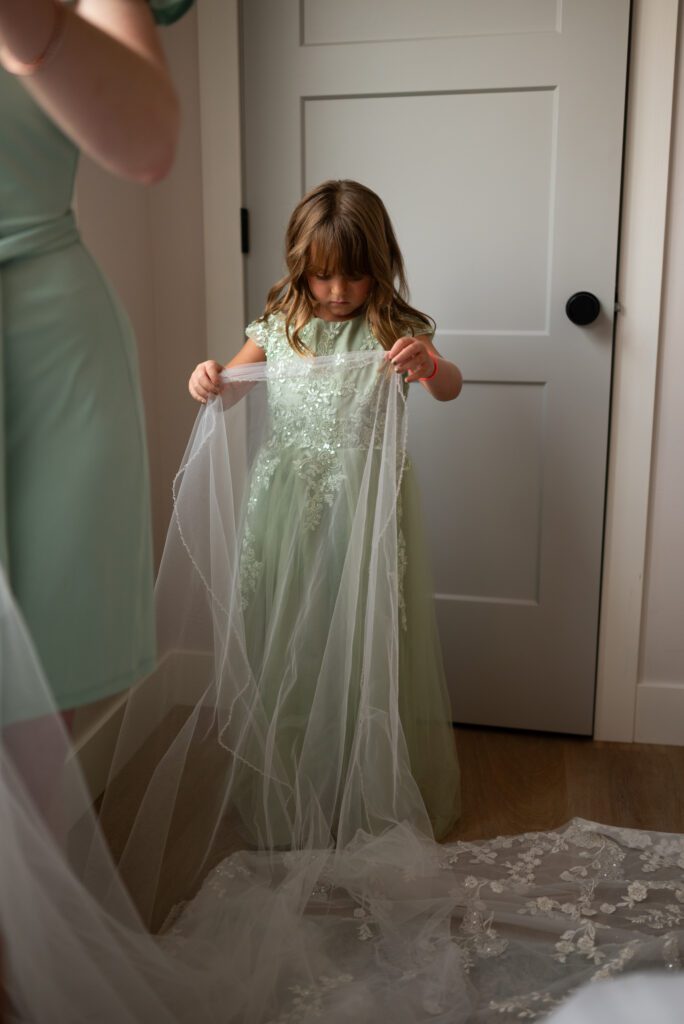 Flower girl fixing bride's dress at Montana mountain wedding