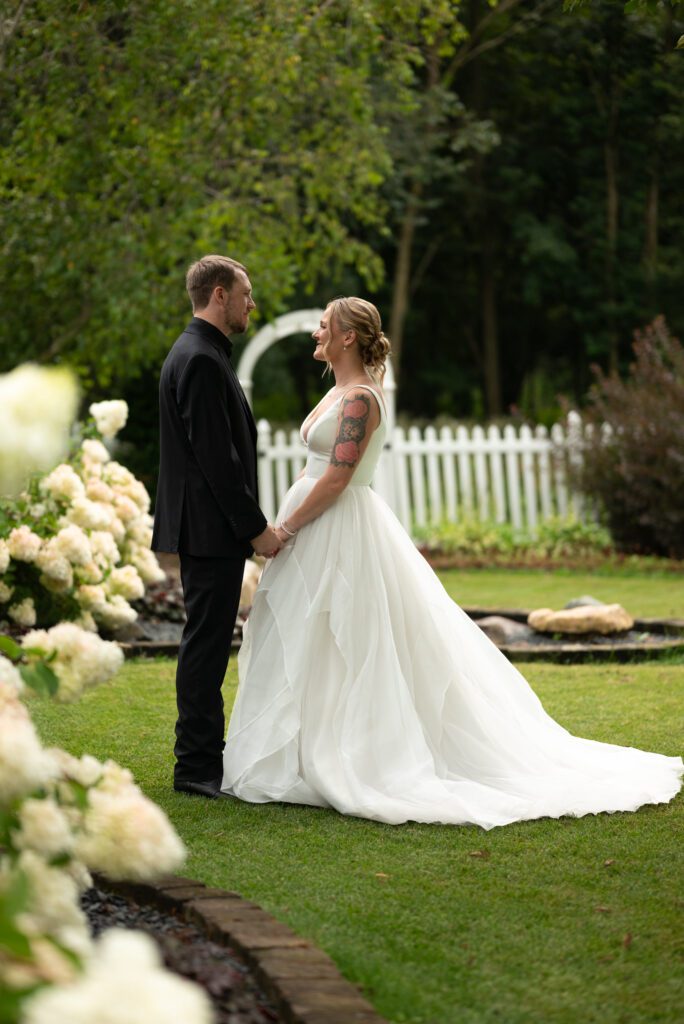 bride and groom amongst the hydrangeas at Blooming Barrel, a garden wedding venue in Baldwin, WI