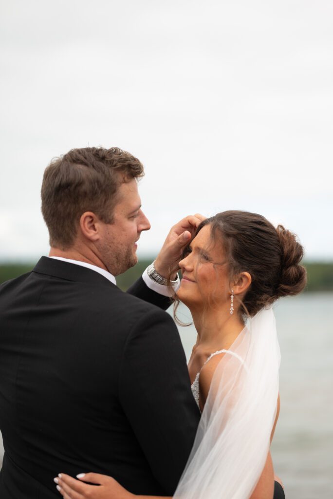 groom wiping hair from bride's face