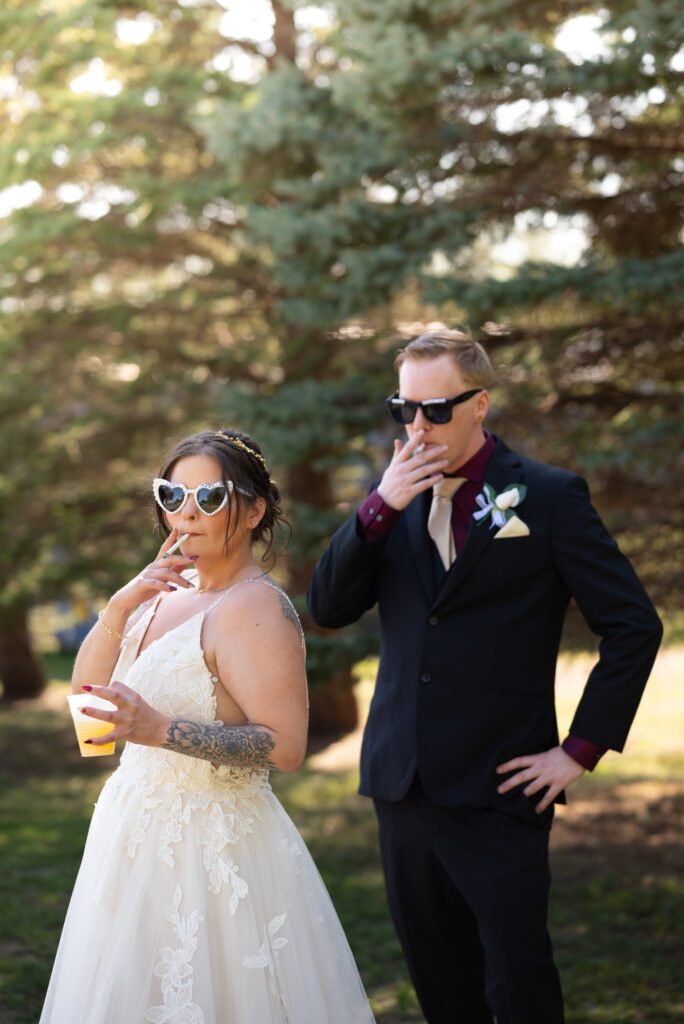 tattooed bride smoking and holding drink, groom smoking and looking at bride