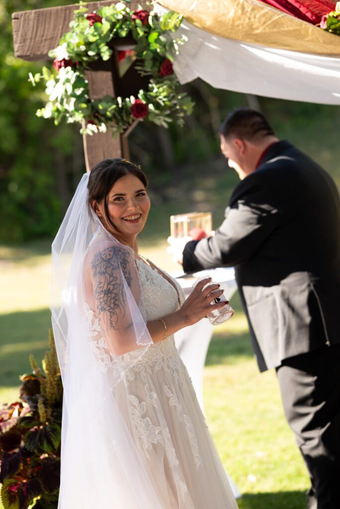 bride during ceremony holding bottle of sand