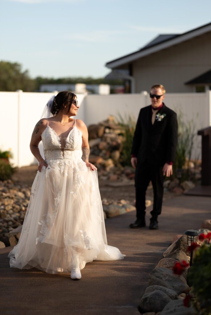 bride walking and looking back at groom, groom looking at bride