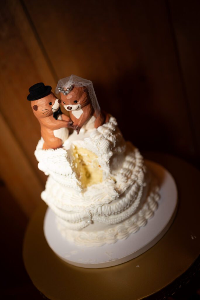 direct flash on cut wedding cake with otter toppers