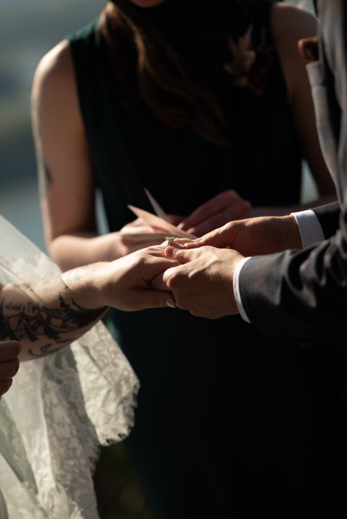 groom putting ring on bride