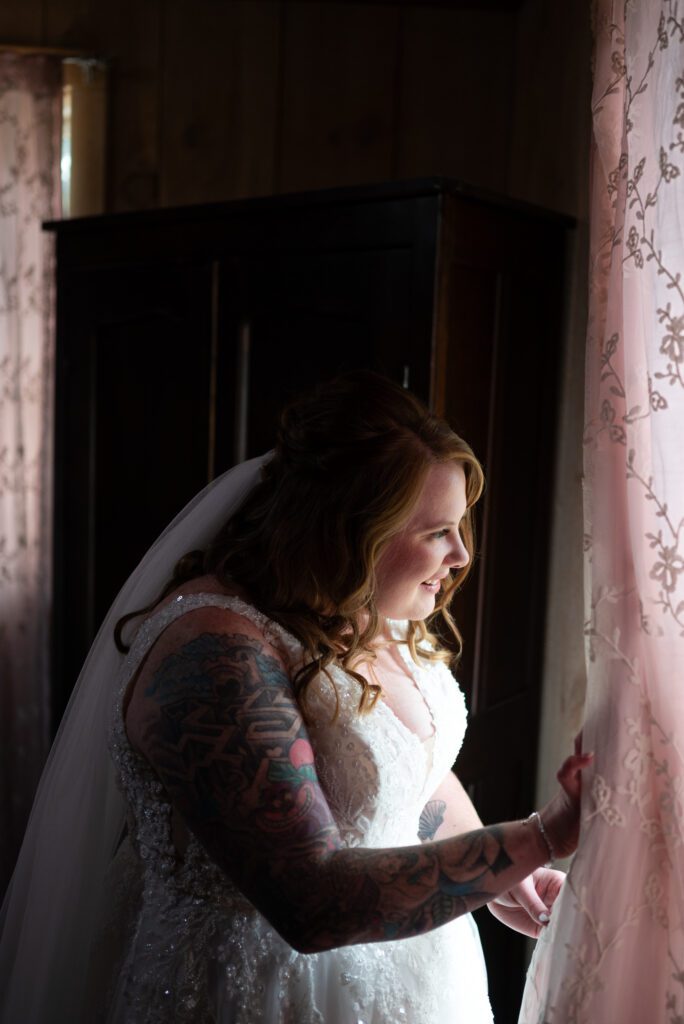 bride peeking out window at guests arriving