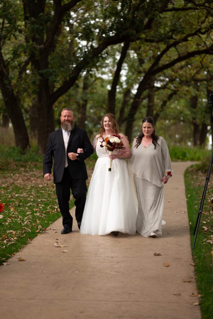 bride walking down the aisle with her parents