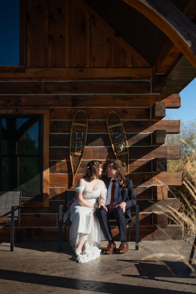 bride and groom in front of cabin