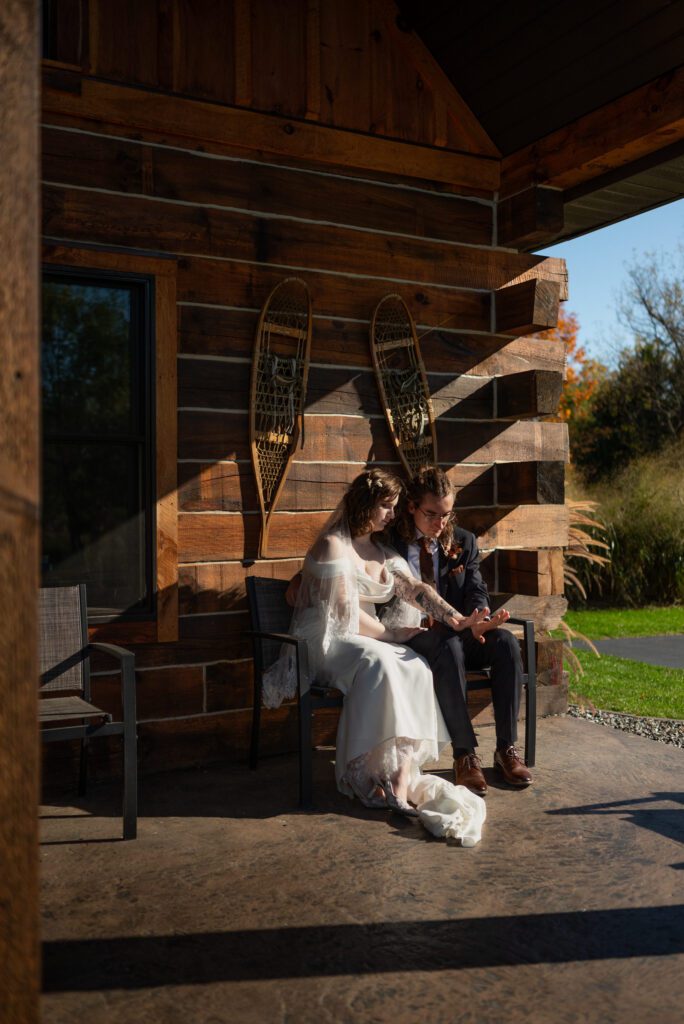 bride and groom sitting on bench in front of De Soto AirBnB cabin at their micro wedding
